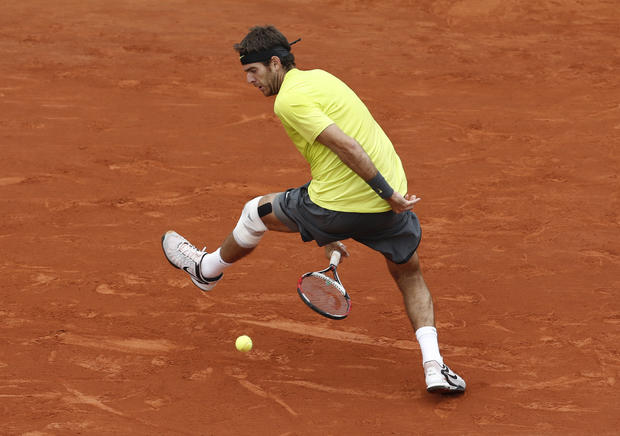 Juan Martin del Potro scores a point as he hits the ball with his racket between his legs 
