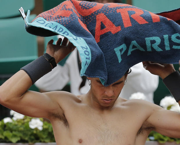 Rafael Nadal  throws a towel over his head 