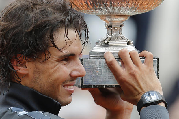 Rafael Nadal of Spain holds the trophy with the inscription of his six previous titles 