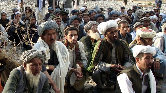 Afghans listen to a national police commander, not pictured, at the site after an earthquake hit Baghlan province, north of Kabul, Afghanistan, June 11, 2012. 