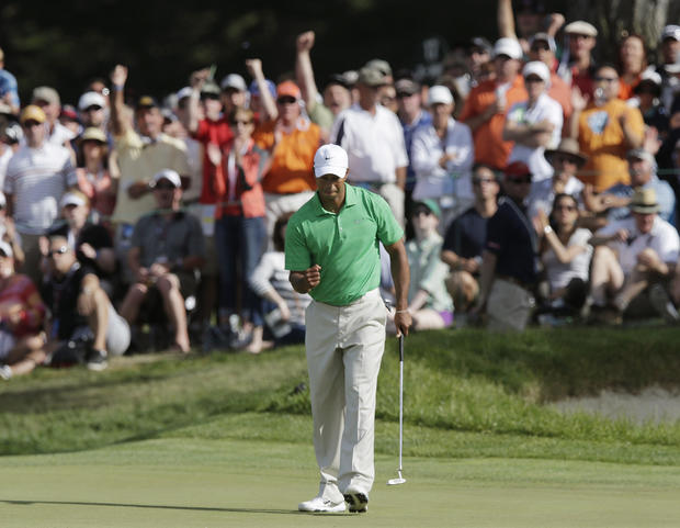 Tiger Woods reacts as be makes a birdie putt  