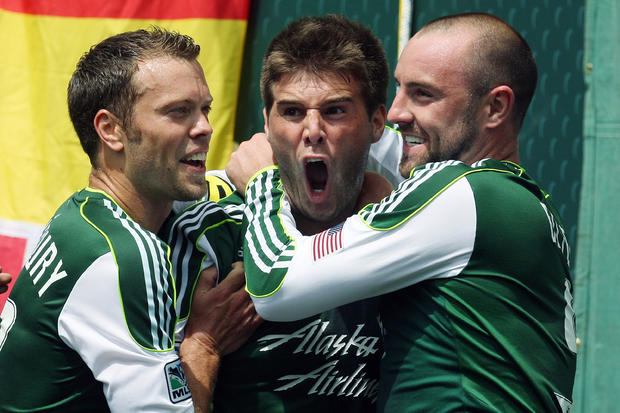 Portland Timbers' David Horst, center, is hugged by Jack Jewsbury, left, and Kris Boyd, right, after scoring in the first half  