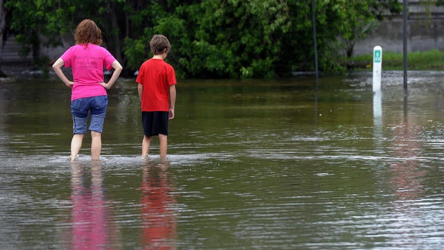 People walk through floodwaters left by Tropical Storm Debby on Anna Maria Island, Fla., Monday 