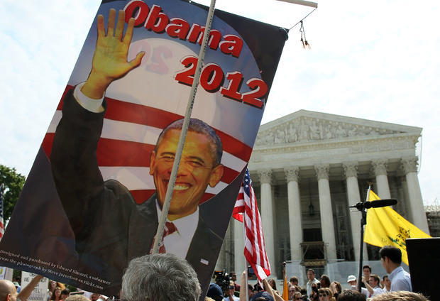 A supporter holds a sign of President Barack Obama in front of the U.S. Supreme Court 