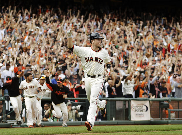 Buster Posey celebrates as he scores 