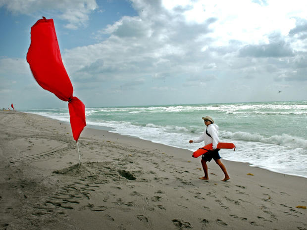 A lifeguard walks on Hallandale Beach in Florida on a windy day. 