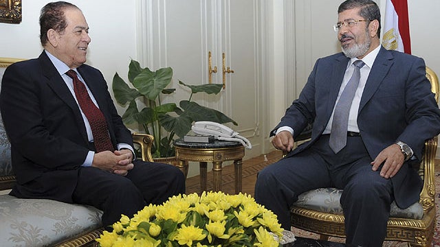 In this image provided by the Egyptian Presidency, Prime Minister Kamal el-Ganzouri, left, meets with President Mohammed Morsi, right, at the Presidential palace in Cairo, July 8, 2012.  