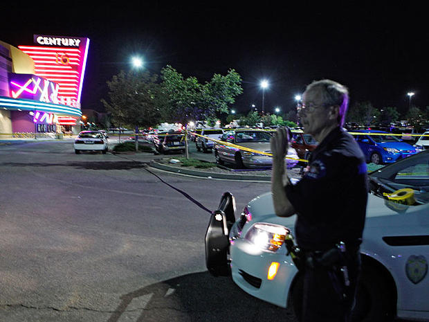 An Aurora Police officer talks on his radio outside of the Century 16 theater at Aurora Mall where as many as 14 people were killed and many injured at a shooting at the Century 16 movie theatre in Aurora, Colo., Friday, July 20, 2012. 