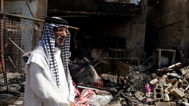 A man stands in front of the scene of a bomb attack in Madain, Iraq, July 23, 2012. 