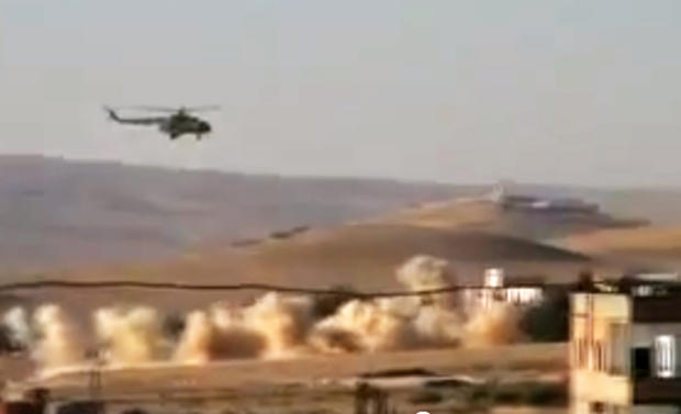 This citizen journalism image provided by Shaam News Network SNN, taken on Tuesday, July 24, 2012, purports to show a helicopter gunship flying a bombing run in al-Qalmoun, Syria. 