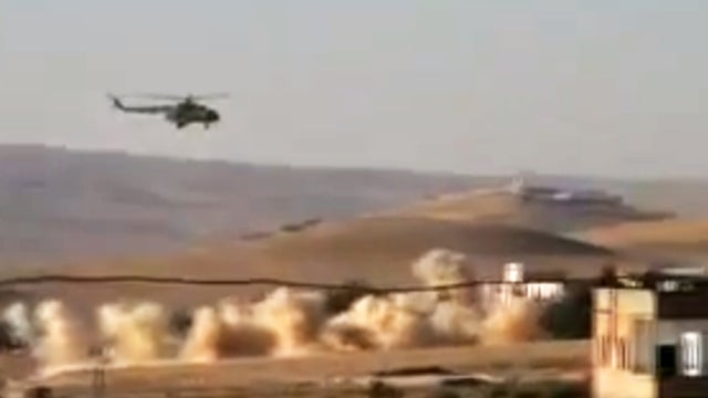 This citizen journalism image provided by Shaam News Network SNN, taken on Tuesday, July 24, 2012, purports to show a helicopter gunship flying a bombing run in al-Qalmoun, Syria. 
