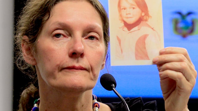 The mother of WikiLeaks founder Julian Assange, Christine Assange, holds up a picture of her son Julian when he was 4-years-old, during a press conference, after meeting with Ecuador's foreign minister in Quito, Ecuador, Monday, July 30, 2012. 