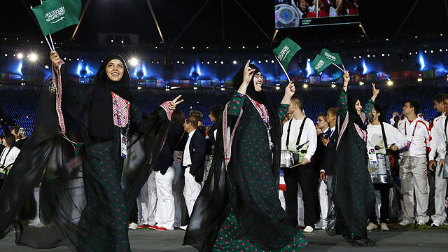 Saudi Arabia's athletes parade, Wojdan Ali Seraj Abdulrahim Shaherkani , center, during the Opening Ceremony at the 2012 Summer Olympics, Friday, July 27, 2012, in London.  