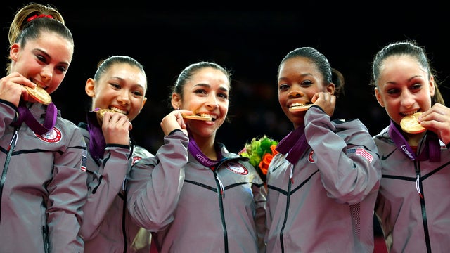 U.S. gymnasts McKayla Maroney, Kyla Ross, Alexandra Raisman, Gabrielle Douglas and Jordyn Wieber bite their gold medals at the artistic gymnastics women's team final at the 2012 Summer Olympics July 31, 2012, in London. 