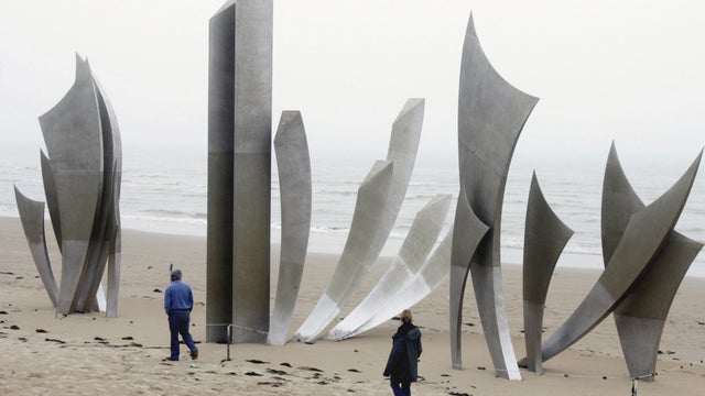 visitors look at the sculpture, "The Braves," erected at Omaha Beach, in memory of Allied soldiers killed on the D Day. 