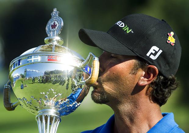 Scott Piercy kisses the trophy after winning the Canadian Open golf 