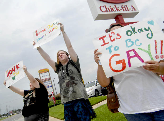 Gay marriage supporters, from left, Emmie Hesley, Cathy Dear and Amy Paffenroth hold signs in front of a Chick-fil-A in Fort Walton Beach, Fla.  