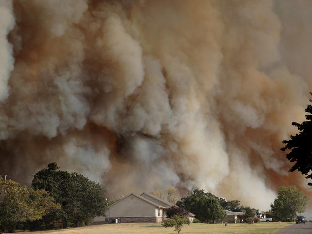 A wildfire burns near homes in Luther, Okla. 