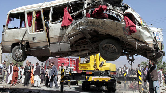 A damaged bus that was hit by a remote-controlled bomb is lifted by a crane on the outskirts of Kabul, Afghanistan, Aug. 7, 2012. 