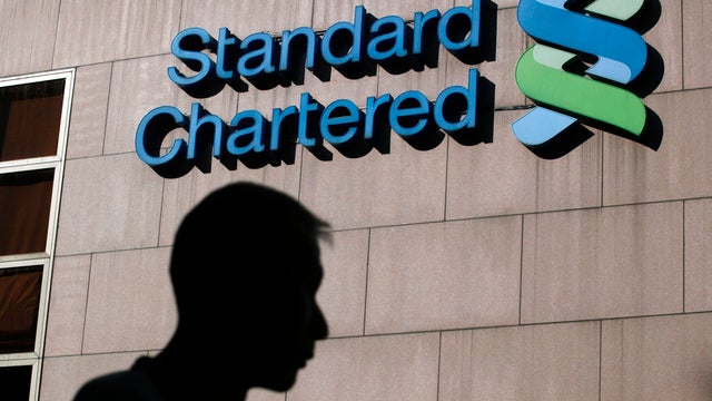 IA man walks past the Standard Chartered Bank building in Hong Kong 