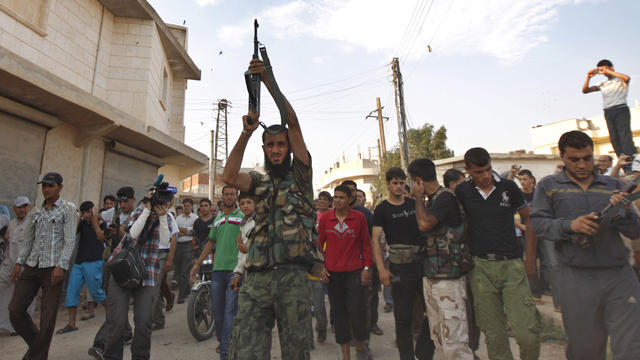 A Syrian gunman shoots in the air during the funeral of Free Syrian Army fighter 