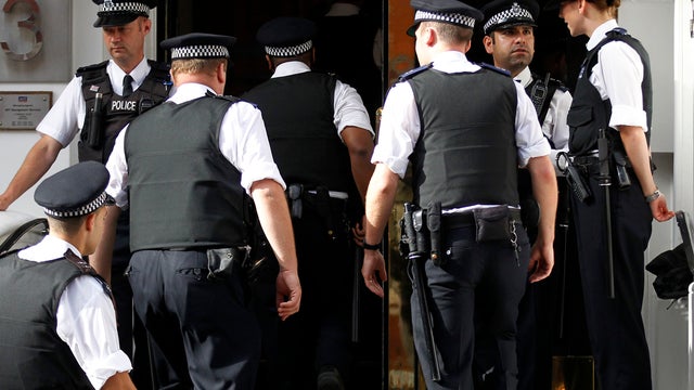 British police officers stand guard outside the Ecuadorian Embassy 
