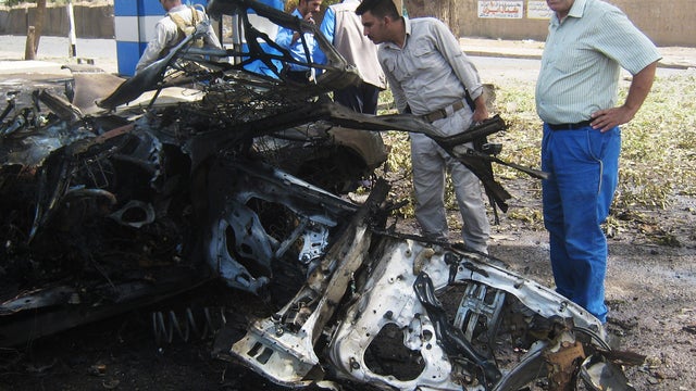 Security forces inspect the scene of a car bomb attack in Kirkuk 