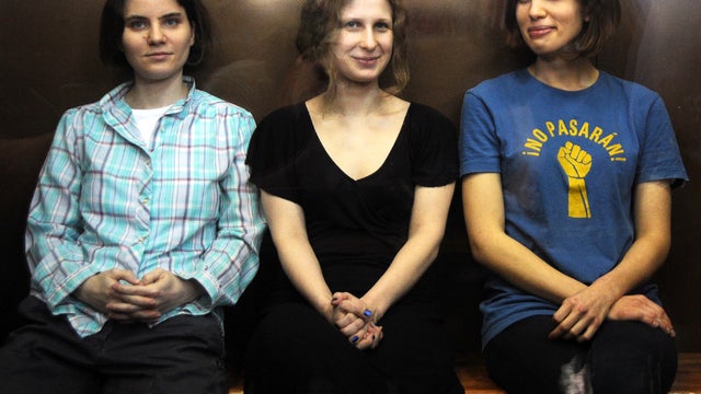 Members of the all-girl punk band Pussy Riot Yekaterina Samutsevich, left, Maria Alyokhina, center, and Nadezhda Tolokonnikova sit in a glass-walled cage during a court hearing in Moscow Aug. 17, 2012. 