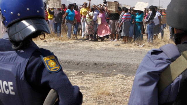 An unidentified woman cries Friday Aug. 17, 2012 as she protests against the police opening fire Thursday and killing and injuring striking mine workers at the Lonmin Platinum Mine near Rustenburg, South Africa.  
