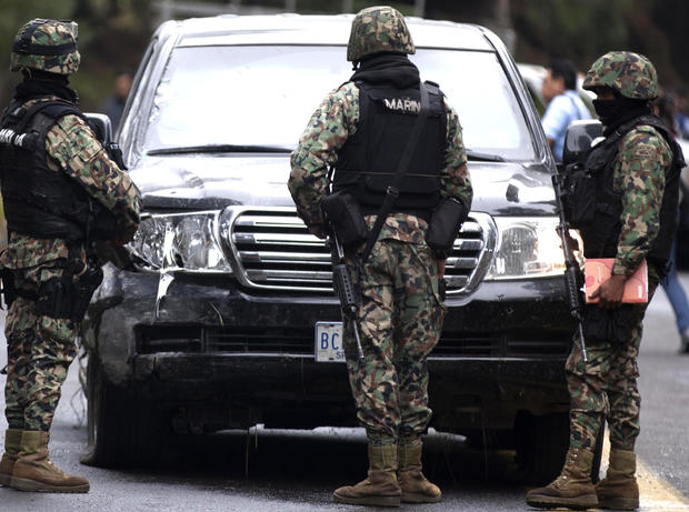 Military guards stand in front of an armored U.S. Embassy vehicle attacked by unknown assailants on the highway leading to the city of Cuernavaca, near Tres Marias, Mexico, Friday, Aug. 24, 2012. 
