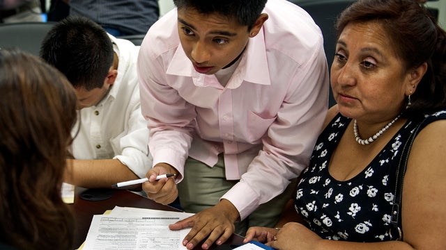 Bolivian Diego Mariaca, center, his mother Ingrid Vaca, right, and brother Gustavo Mariaca fill out paperwork under the Obama administration's Deferred Action for Childhood Arrivals plan Aug. 15, 2012, at the National Immigration Forum in Washington. 