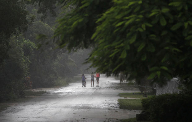 People venture out into the storm as Tropical Storm Isaac begins to move ashore 