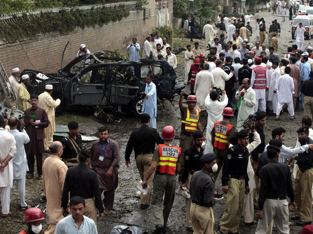 Officials and rescue volunteers gather at the bombing site in Peshawar 