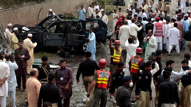 Officials and rescue volunteers gather at the bombing site in Peshawar 