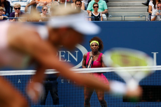 Andrea Hlavackova returns a shot to Serena Williams  