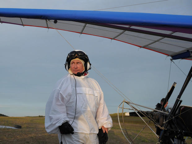 Russian President Vladimir Putin stands beside a motorized hang glider 
