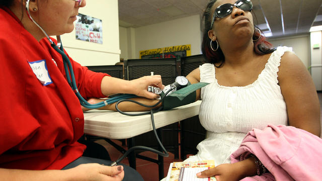 Nurse Allison Miller, left, checks the blood pressure of Keri Anderson as nurses and physicians give free basic health screenings to call attention to what they say is an ongoing health care emergency July 10, 2012, in Los Angeles. 