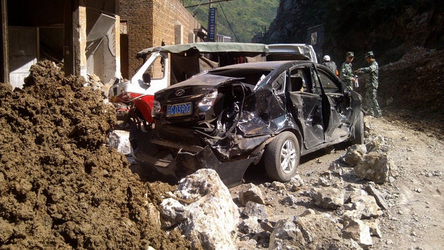 In this photo provided by China's Xinhua News Agency, damaged cars are seen in Luozehe town, Yiliang County, southwest China's Yunnan Province, Friday, Sept. 7, 2012.  