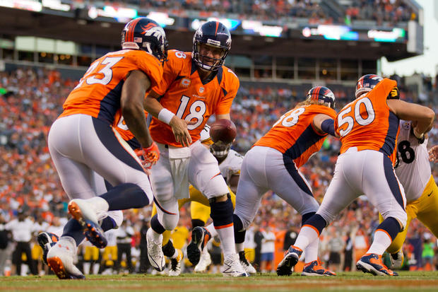 Peyton Manning hands the ball off to running back Willis McGahee 