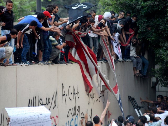 Protesters destroy an American flag pulled down from the U.S. Embassy in Cairo Sept. 11, 2012. 