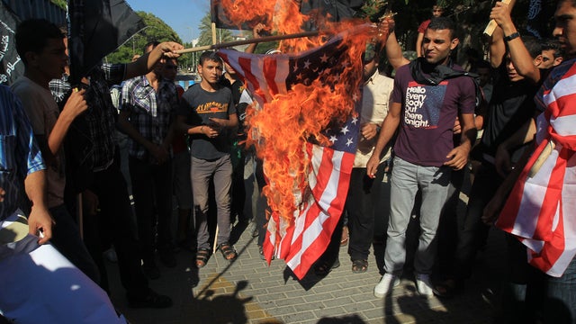 Palestinian men burn the U.S. flag during a demonstration against a film deemed offensive to Islam 