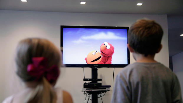 In this Sept. 5, 2012, photo, from left, Zoe Shyba, 3, and Aidan Lain, 7, play "Kinect Sesame Street TV" at the Sesame Street Workshop in New York. "Kinect Sesame Street TV", launching Tuesday, Sept. 18, 2012, uses Kinect, a motion and voice-sensing controller created by Microsoft, to give Elmo, Big Bird and the rest of the Sesame Street crew a chance to have a real two-way conversation with their pint-sized audience. The effort represents the next step in the evolution of television, adding an interactive element to what's still largely a passive, lean-back experience. 
