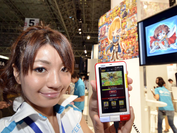 A model displays a smartphone loading up a game at the booth of Japan's mobile social networking service company Gree at the annual Tokyo Game Show in Chiba, suburban Tokyo, on September 15, 2011. Some 200 companies from 16 countries exhibited their latest video game hardwares and softwares at a four-day vent. AFP PHOTO / Yoshikazu TSUNO (Photo credit should read YOSHIKAZU TSUNO/AFP/Getty Images) 