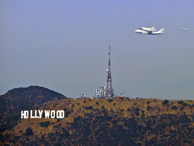 The Space Shuttle Endeavour atop a modified 747 passes the Hollywood Sign as seen from Dodger Stadium, Friday, Sept. 21, 2012, in Los Angeles, the last aerial hurrah before retiring to a Los Angeles museum. (AP Photo/Mark J. Terrill) 