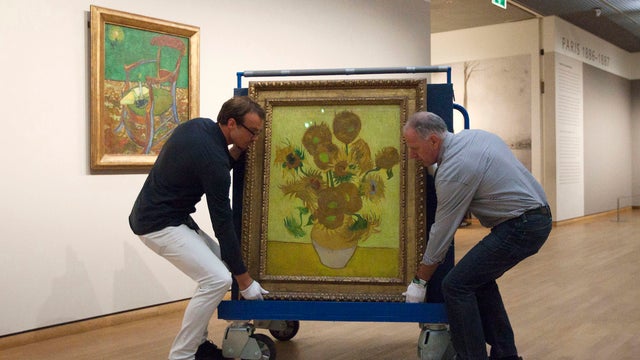 Curators put Vincent van Gogh's famous "Sunflowers" painting onto a felt-lined carrier trolley at the Van Gogh Museum in Amsterdam, Netherlands, Sunday, Sept. 23, 2012.  