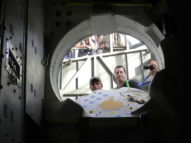 Patch-eye view: NASA techs look into space shuttle Endeavour's crew cabin after storing patches and a photo on board for the orbiterÃ¢s final ferry flight. 