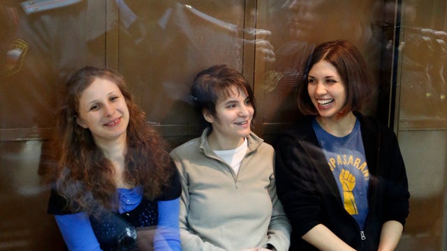 Feminist punk group Pussy Riot members sit in a glass cage at a court room in Moscow 