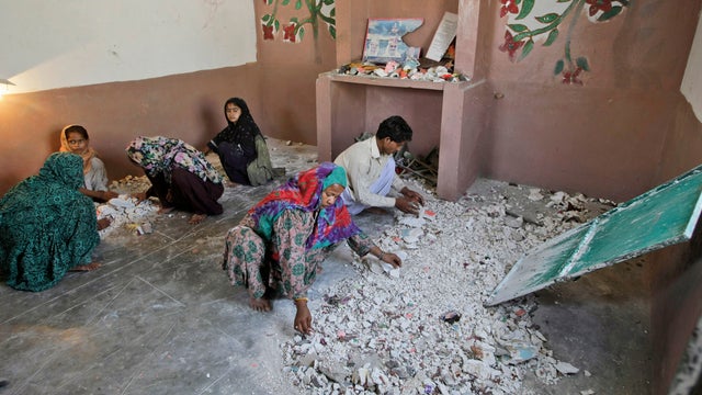 Hindus clean a temple in Karachi, Pakistan, Sunday, Sept. 30, 2012 after being attacked by a group of Muslim men. 