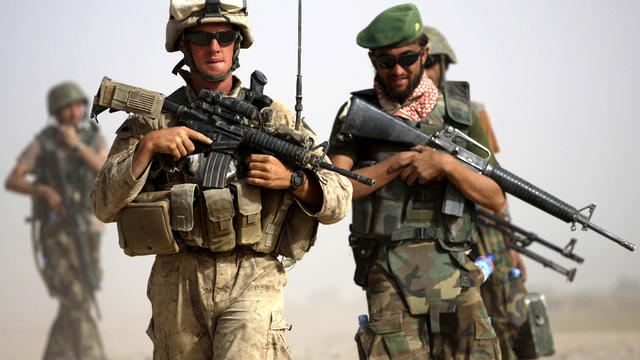 U.S. Marine squad leader Sgt. Matthew Duquette, left, of Warrenville, Ill., walks with Afghan National Army Lt. Hussein during a joint patrol in Nawa district, Helmand province, Afghanistan, Oct. 3, 2009. 