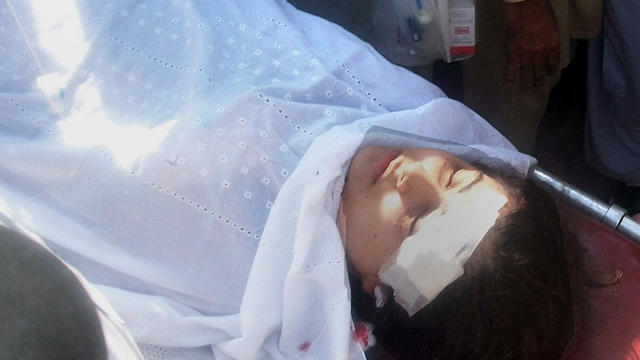 A wounded Pakistani girl, Malala Yousufzai, is moved to a helicopter. 